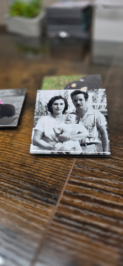 Black and white photo of a family on a wooden surface with other photos in the background.